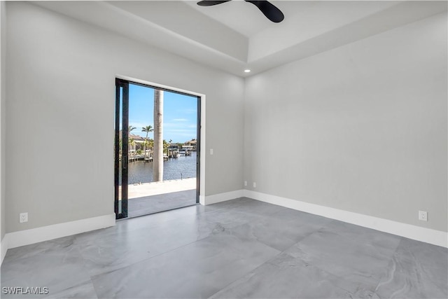 spare room with a water view and ceiling fan