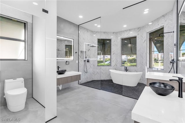 full bathroom with vanity, toilet, separate shower and tub, and a wealth of natural light