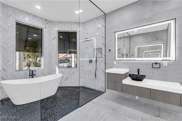 bathroom featuring tile walls, vanity, and plus walk in shower