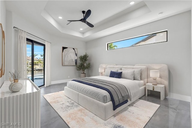 bedroom with access to outside, a raised ceiling, ceiling fan, and a water view