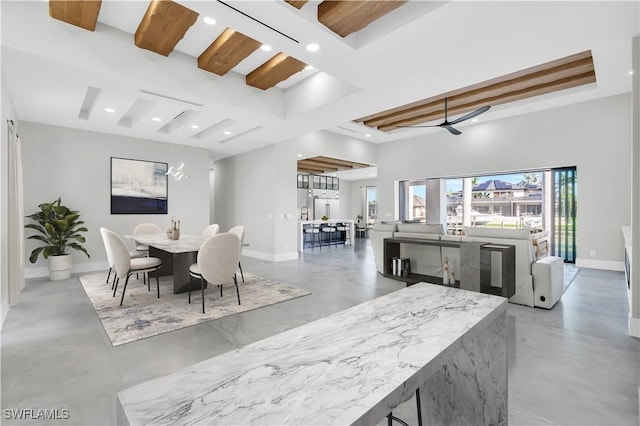 dining space with a towering ceiling and beam ceiling