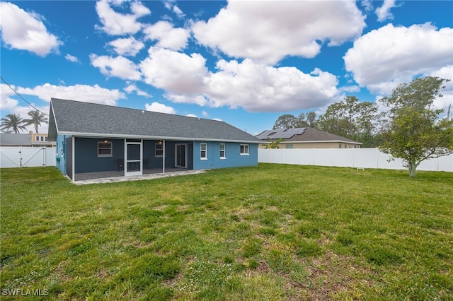 rear view of property featuring a yard