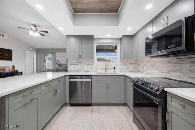 kitchen featuring gray cabinetry, sink, light stone countertops, and stainless steel appliances