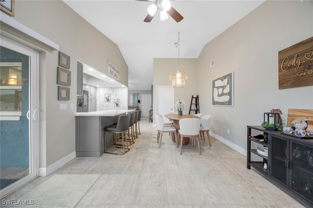 dining area with ceiling fan and vaulted ceiling