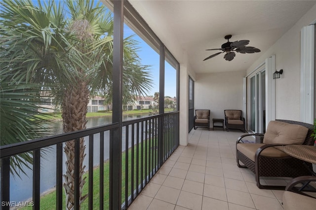 sunroom / solarium featuring ceiling fan and a water view