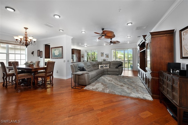 living room with ceiling fan with notable chandelier, dark hardwood / wood-style floors, and ornamental molding