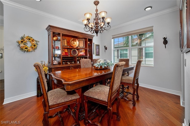 dining space featuring wood-type flooring, crown molding, and a notable chandelier