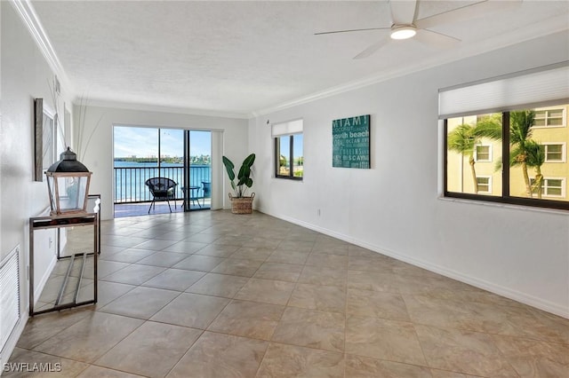 spare room with ceiling fan, light tile patterned flooring, crown molding, a textured ceiling, and a water view