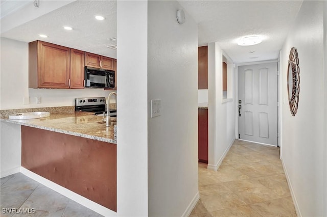 interior space featuring sink, light tile patterned floors, and a textured ceiling