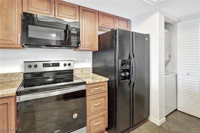 kitchen with light stone countertops, light tile patterned floors, a textured ceiling, and black appliances