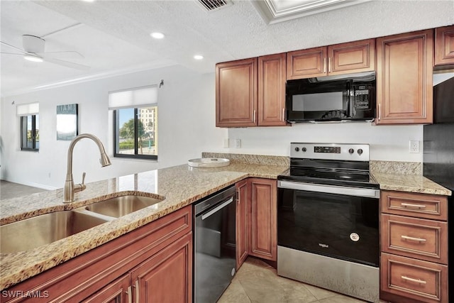 kitchen with black appliances, light stone counters, sink, and a textured ceiling