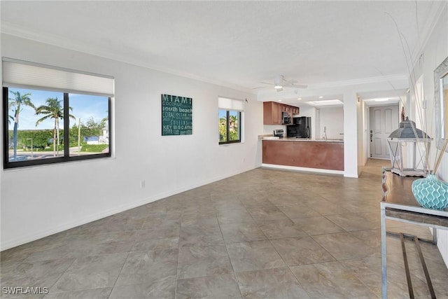 unfurnished living room featuring crown molding, sink, ceiling fan, and light tile patterned flooring