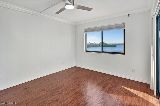 empty room with crown molding, dark hardwood / wood-style flooring, a water view, and ceiling fan