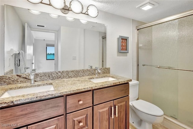 bathroom featuring a textured ceiling, vanity, toilet, and an enclosed shower