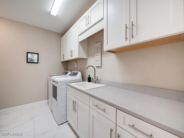 laundry area featuring cabinets, washing machine and dryer, and sink