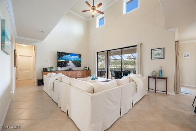 tiled living room featuring ceiling fan, crown molding, and a towering ceiling