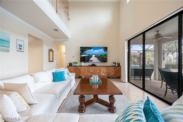 tiled living room with ceiling fan and a towering ceiling