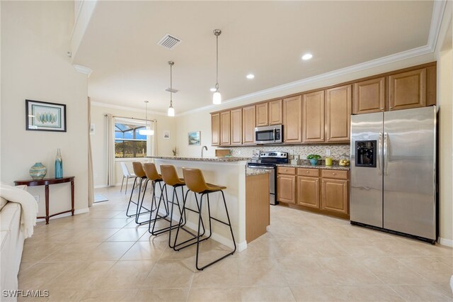 kitchen with a center island, hanging light fixtures, light stone countertops, ornamental molding, and stainless steel appliances