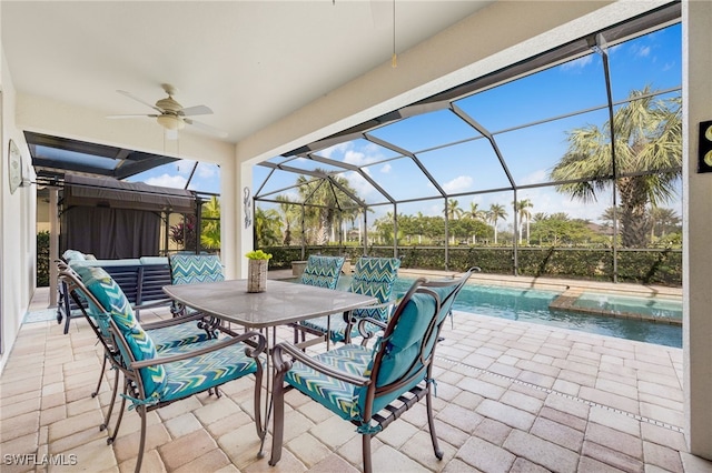 view of patio featuring an outdoor hangout area, glass enclosure, and ceiling fan