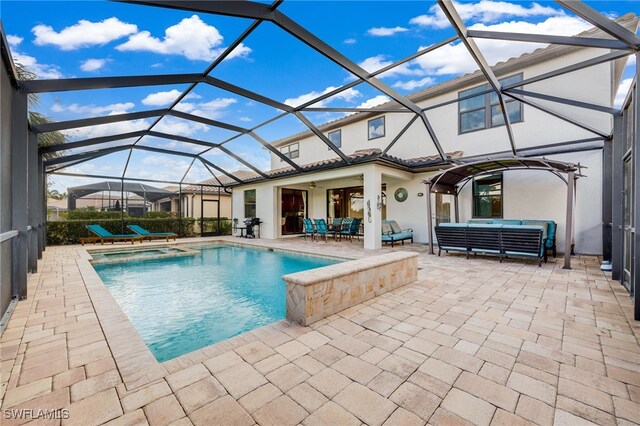 view of pool with glass enclosure, ceiling fan, a patio area, and an in ground hot tub