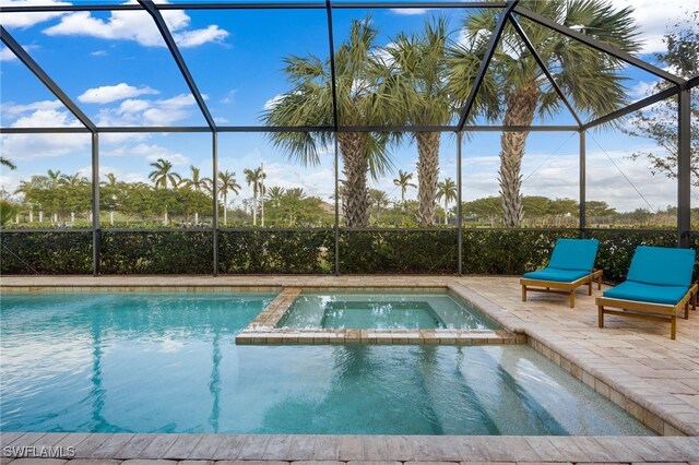 view of pool featuring a lanai, an in ground hot tub, and a patio