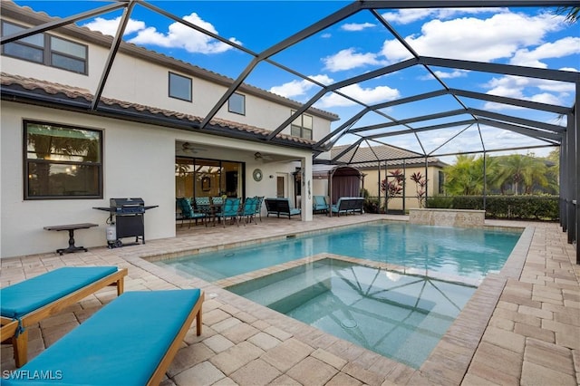 view of swimming pool with glass enclosure, ceiling fan, grilling area, an in ground hot tub, and a patio