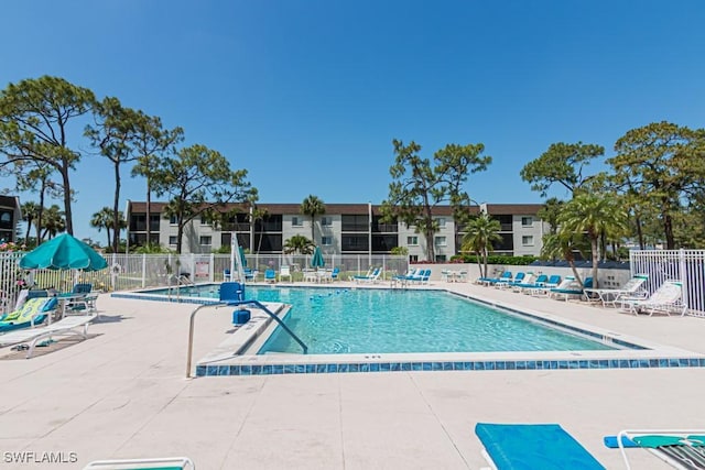 community pool featuring fence and a patio