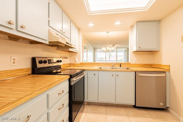 kitchen with stainless steel appliances, under cabinet range hood, light countertops, and a sink
