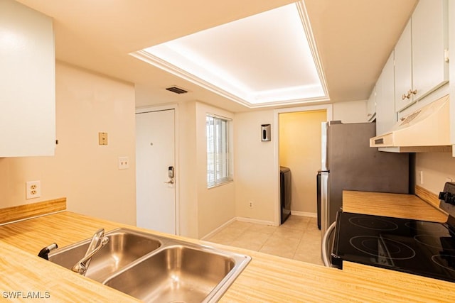 kitchen featuring visible vents, a sink, under cabinet range hood, stainless steel range with electric cooktop, and light tile patterned flooring