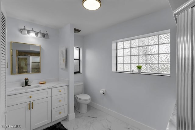 bathroom with vanity, a shower with shower door, and toilet