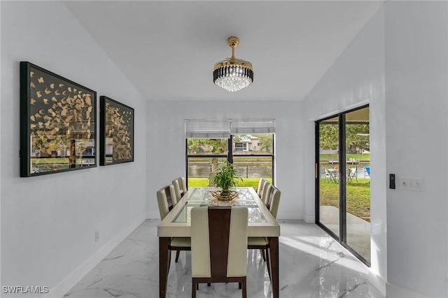 dining room with vaulted ceiling and an inviting chandelier