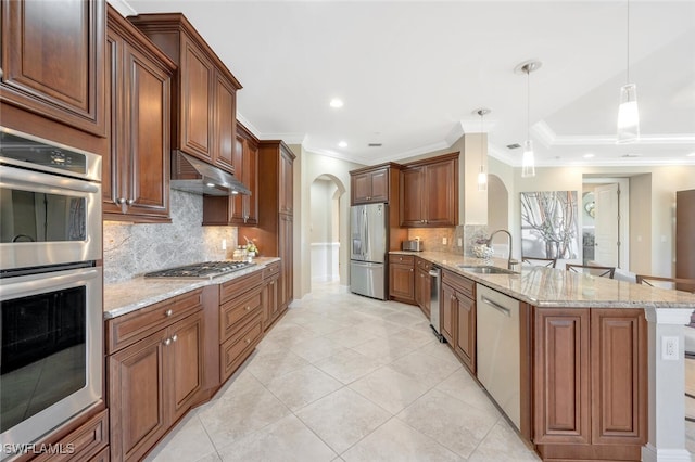 kitchen with arched walkways, under cabinet range hood, a peninsula, a sink, and appliances with stainless steel finishes