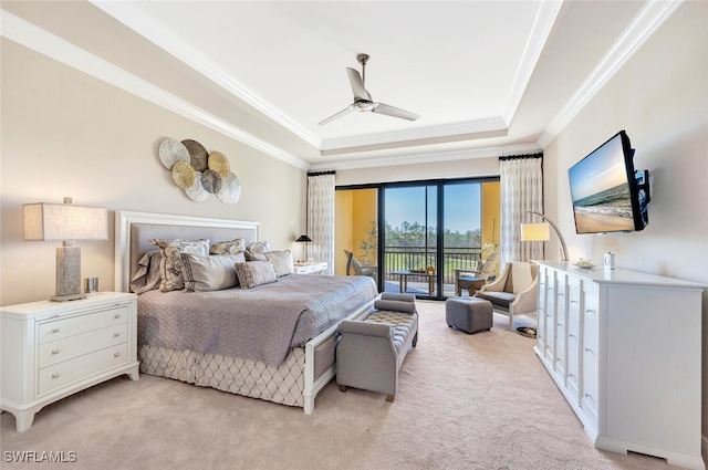 bedroom featuring access to exterior, a tray ceiling, crown molding, and light colored carpet