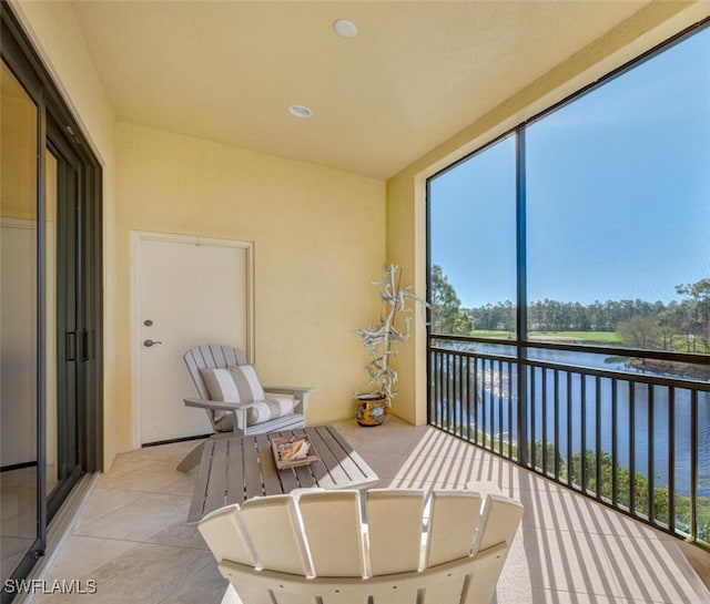 sunroom featuring a water view