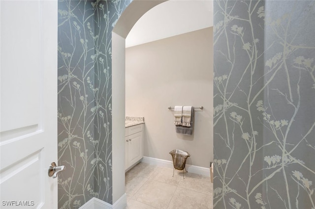 bathroom with vanity, baseboards, and tile patterned floors