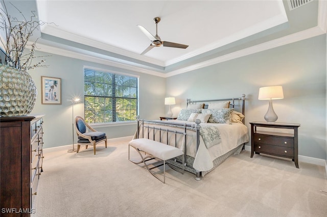 bedroom featuring a raised ceiling, light carpet, and baseboards