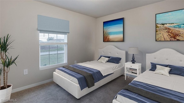 bedroom with dark carpet and baseboards