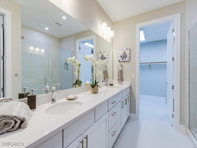 bathroom featuring a shower with door and vanity