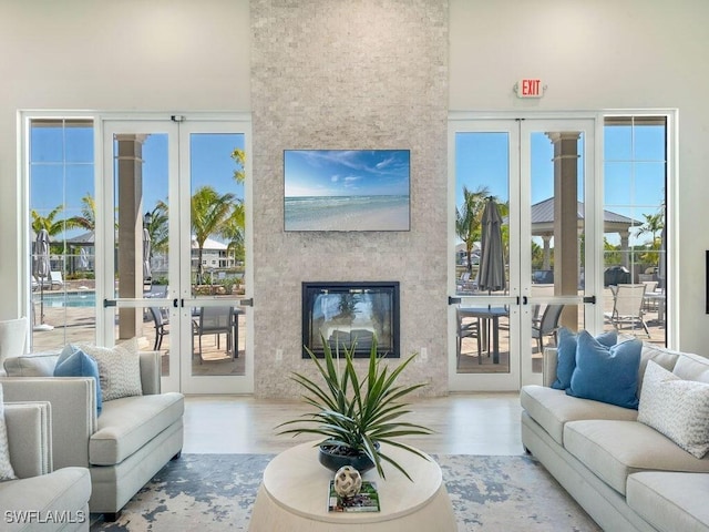 living room with french doors, a large fireplace, and hardwood / wood-style flooring