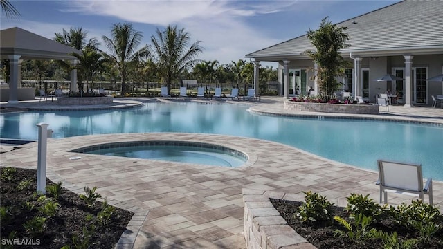 view of pool featuring a community hot tub and a patio area