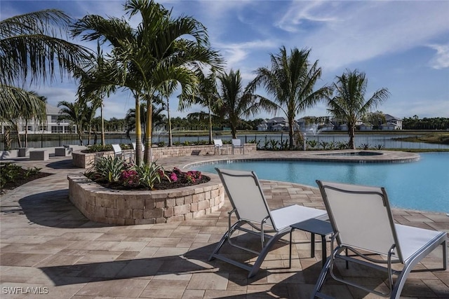 view of pool featuring a water view, a patio, and a hot tub