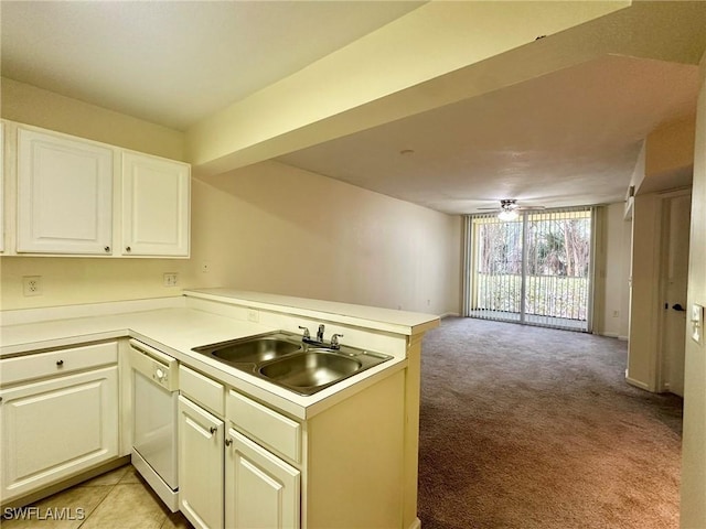 kitchen featuring sink, kitchen peninsula, white dishwasher, light colored carpet, and white cabinets