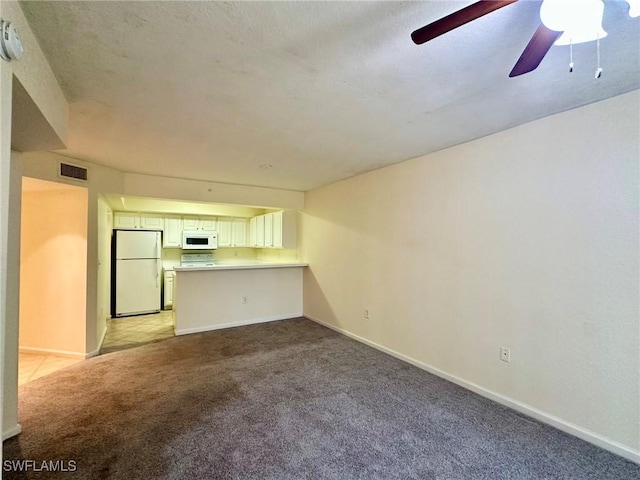 unfurnished living room featuring light carpet and ceiling fan