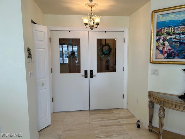 foyer entrance featuring french doors, light tile patterned floors, and a notable chandelier