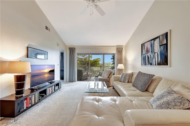 carpeted living room with ceiling fan and high vaulted ceiling