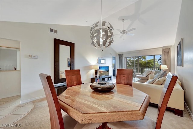 dining room with ceiling fan with notable chandelier, light tile patterned flooring, and lofted ceiling