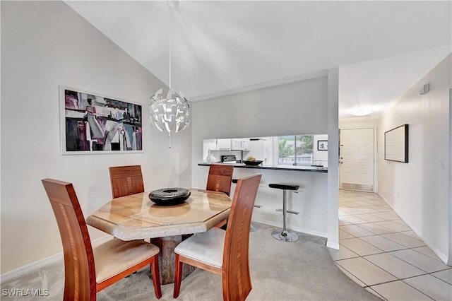 dining space with an inviting chandelier, light tile patterned floors, and vaulted ceiling