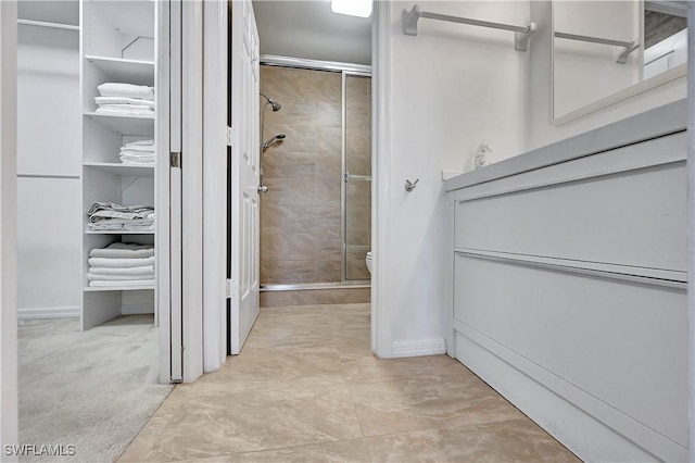 bathroom featuring toilet and a shower with shower door