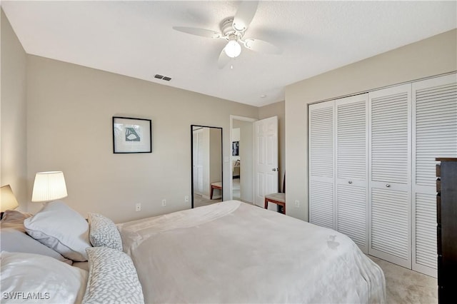 bedroom with ceiling fan, a closet, and light carpet