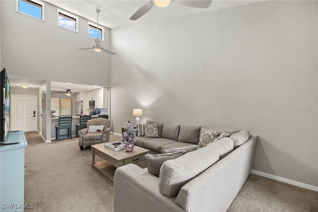 carpeted living room featuring a towering ceiling